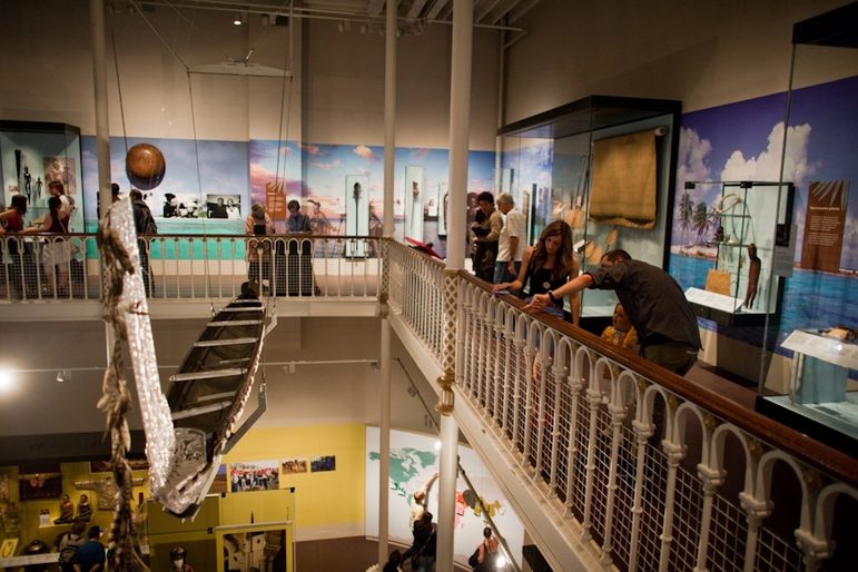 A group of museum visitors look at collection displays