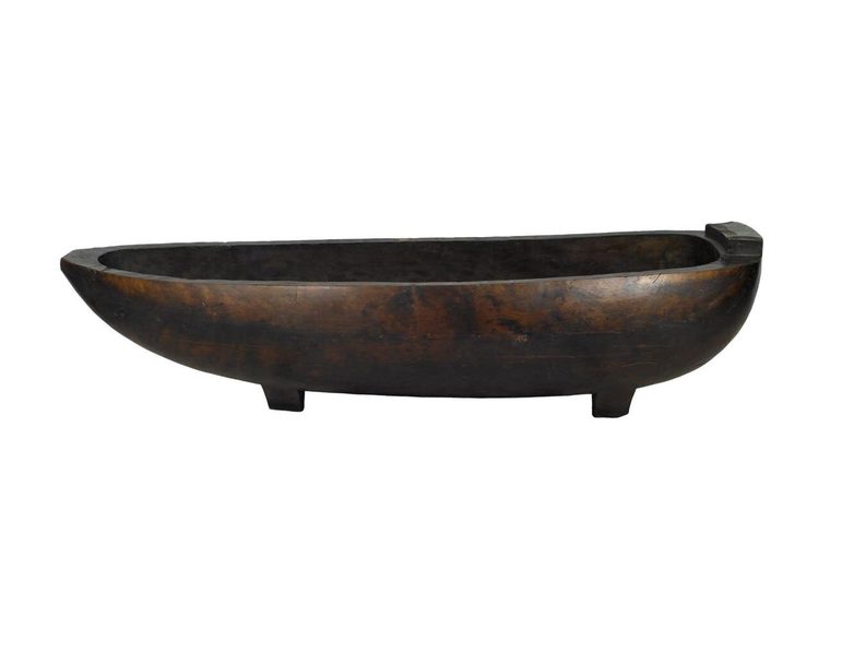 A large dark oval wooden vessel that is hollow in the middle and stands on two short legs