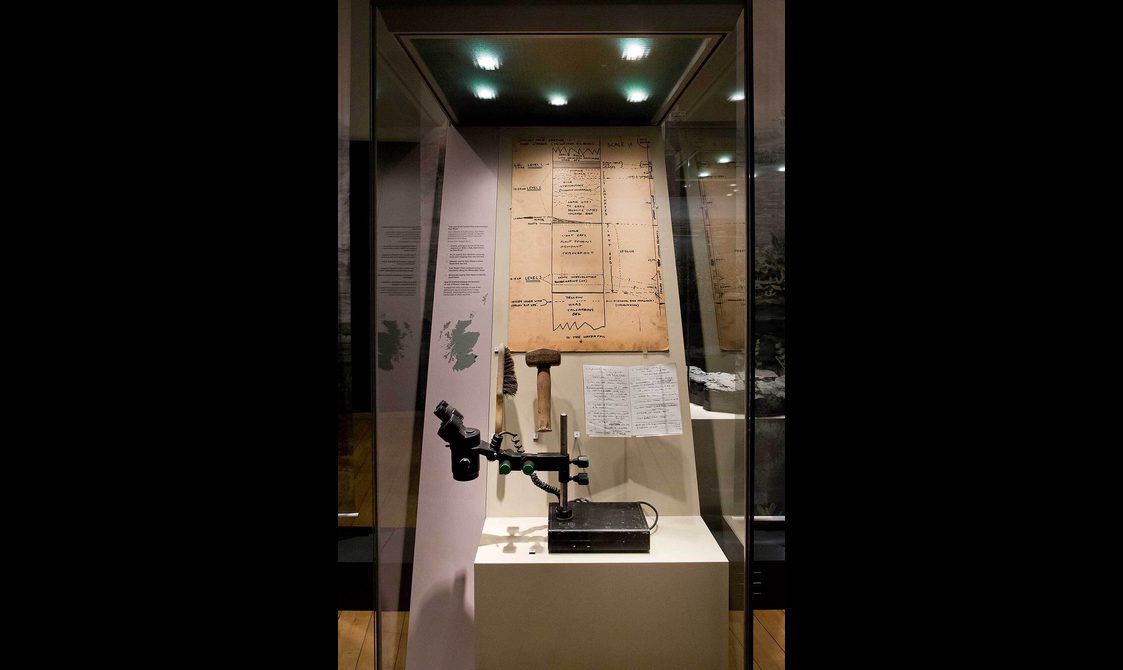 Instruments used to examine fossils in a museum display case.