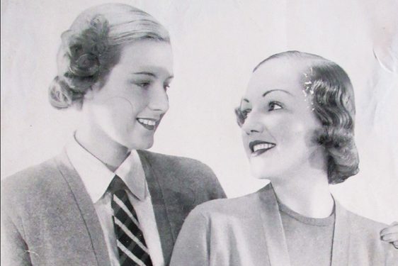 Black and white photograph of two women modelling Pringle of Scotland cardigans.