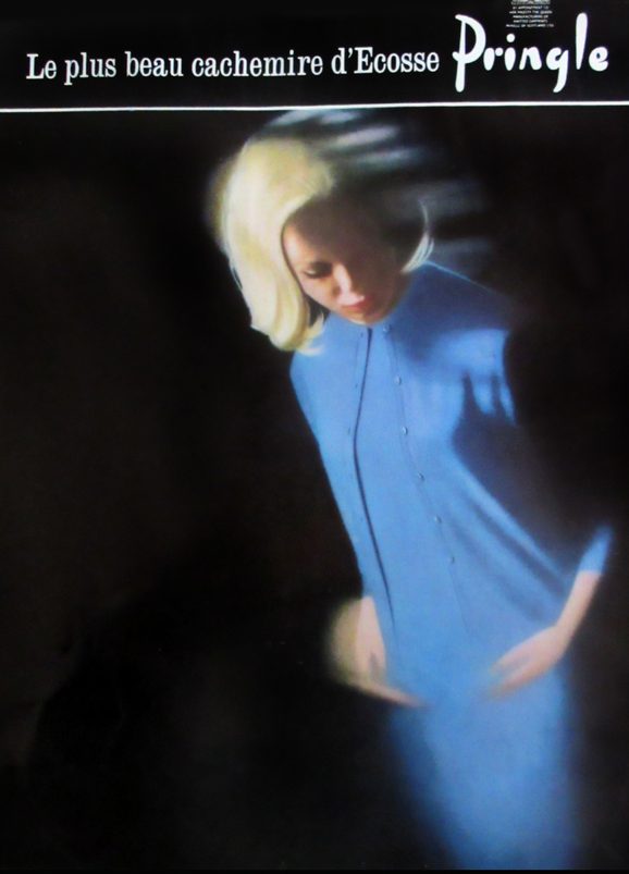 The front of a fashion magazine with a model wearing a blue dress designed by Pringle.