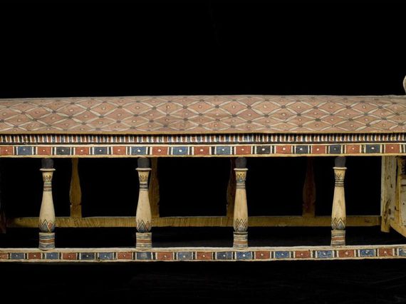 A wooden canoppy painted in a faded black, blue, and red pattern.