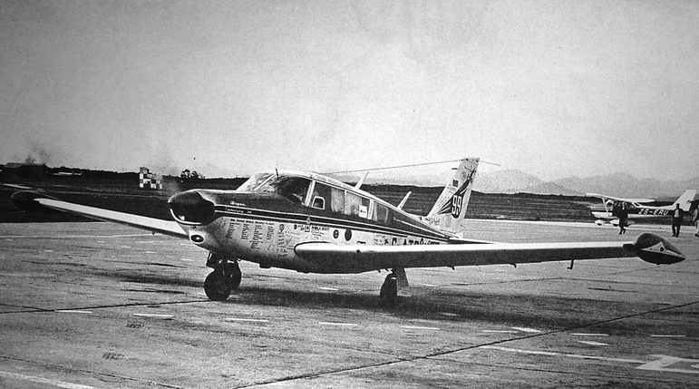 Black and white photograph of the Piper PA-24 'Comanche' 260B aircraft parked on a runway.