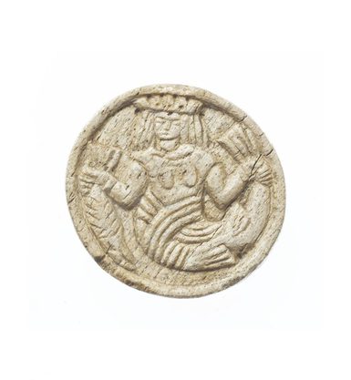 A beige stone disc with a stylised mermaid wearing a crowd etched into the surface