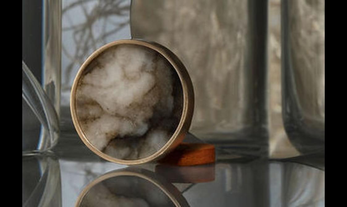 A round brooch with a gold rim.