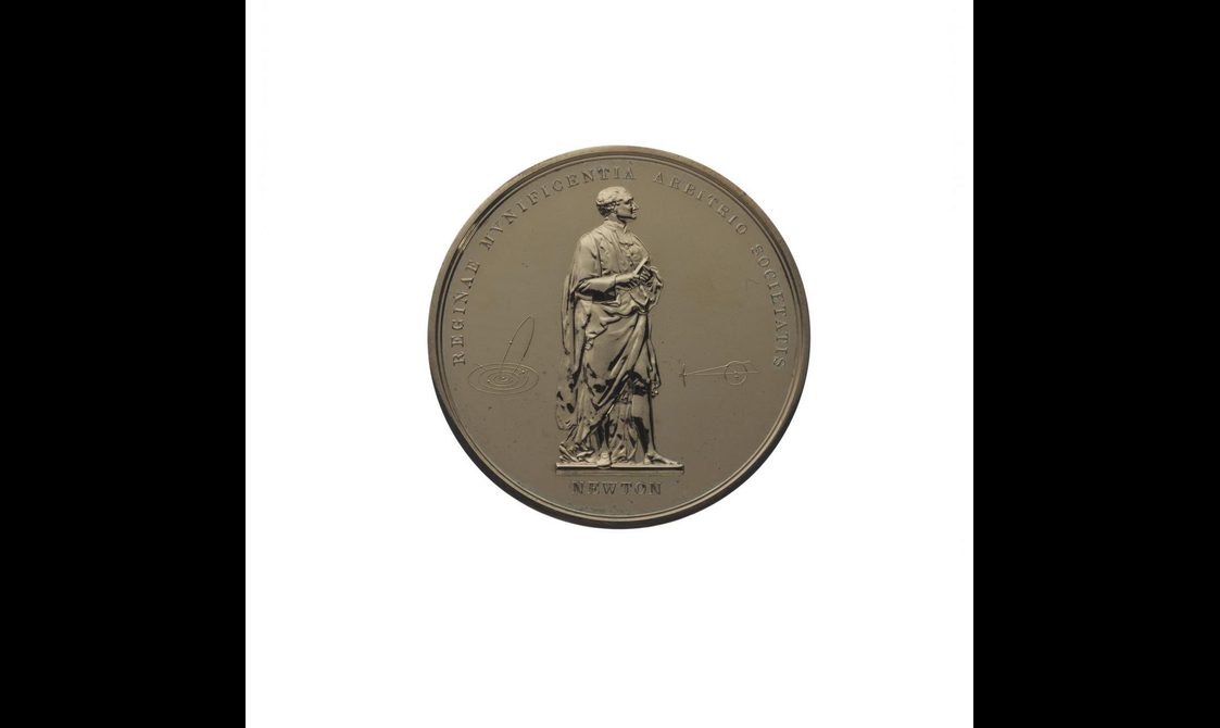 A round gold medal with a man standing in the middle and text around the edge
