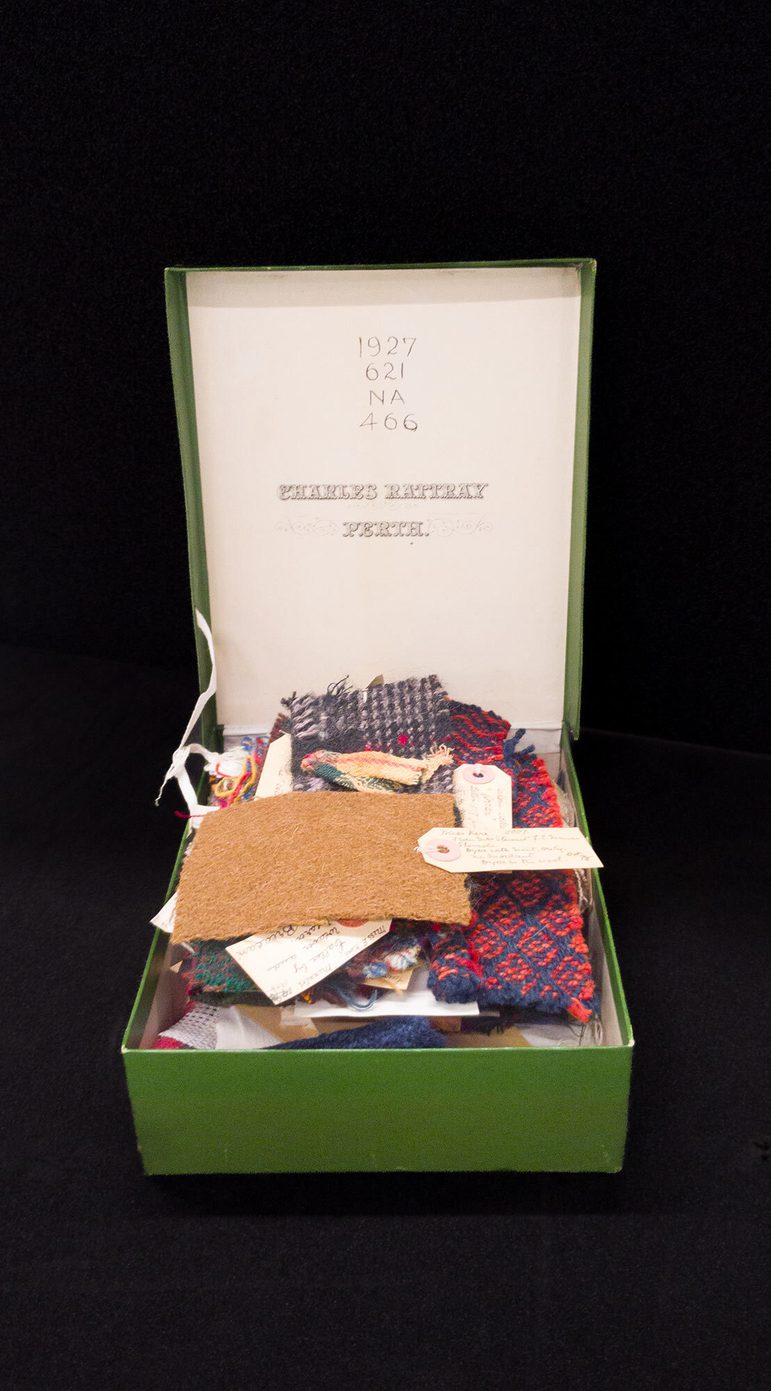An open green box with small samples of different colourful fabrics inside