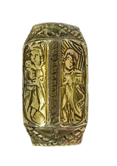 A gold finger ring, which is carved with religious imagery.