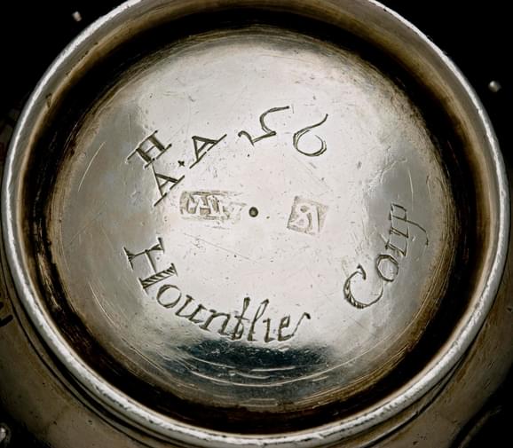 The bottom of a silver cup with an inscription