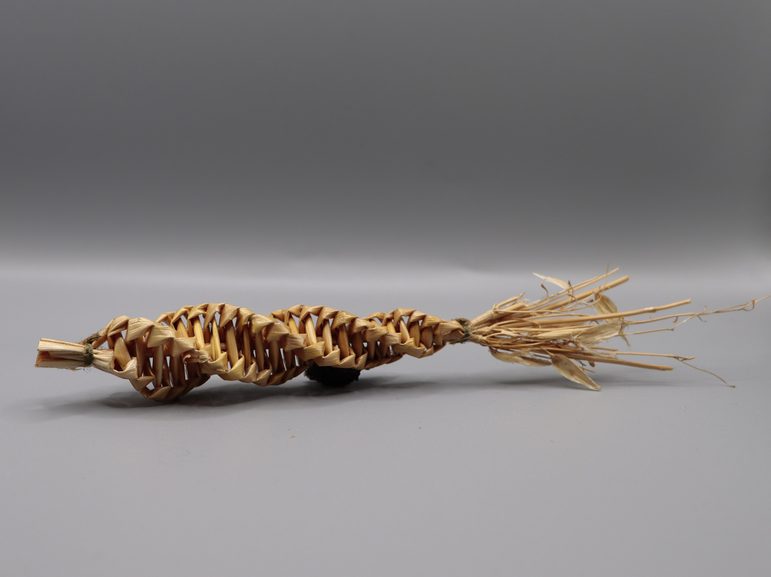 Strands of grain have been twisted and plaited into a small, sculptural shape that looks a bit like an ear of corn.