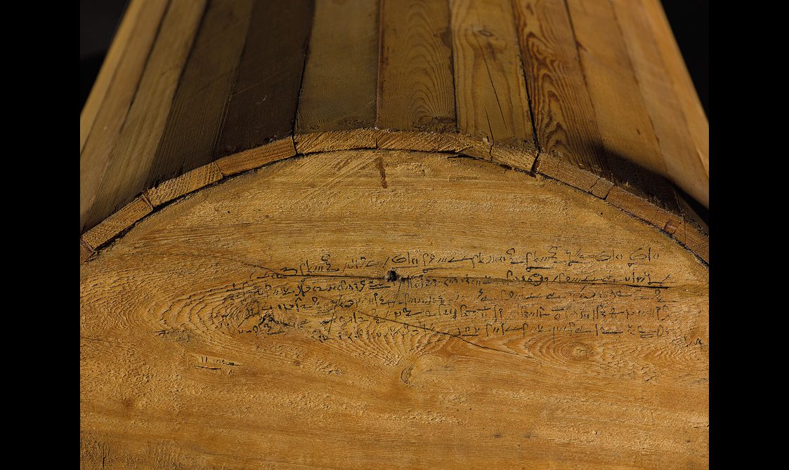 A detail of a wooden coffin lid with an inscription written in Hieratic script.