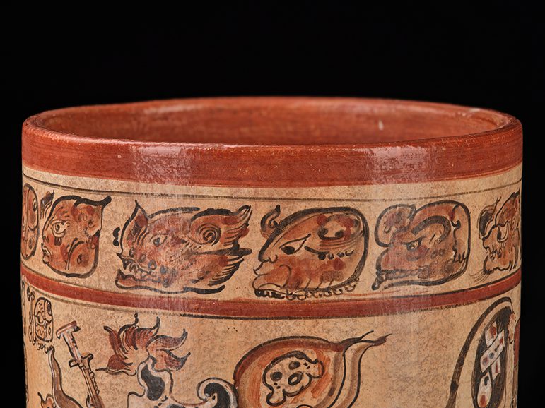 Ancient Mayan ceramic bowl featuring intricate designs including animal and mythological figures on a black background.