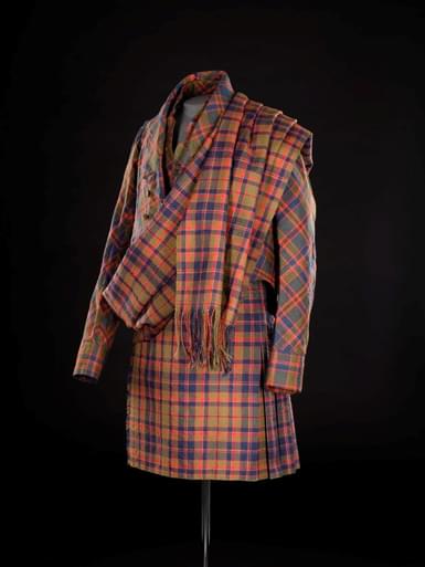 A mannequin wearing a tartan kilt, jacket, and shawl.