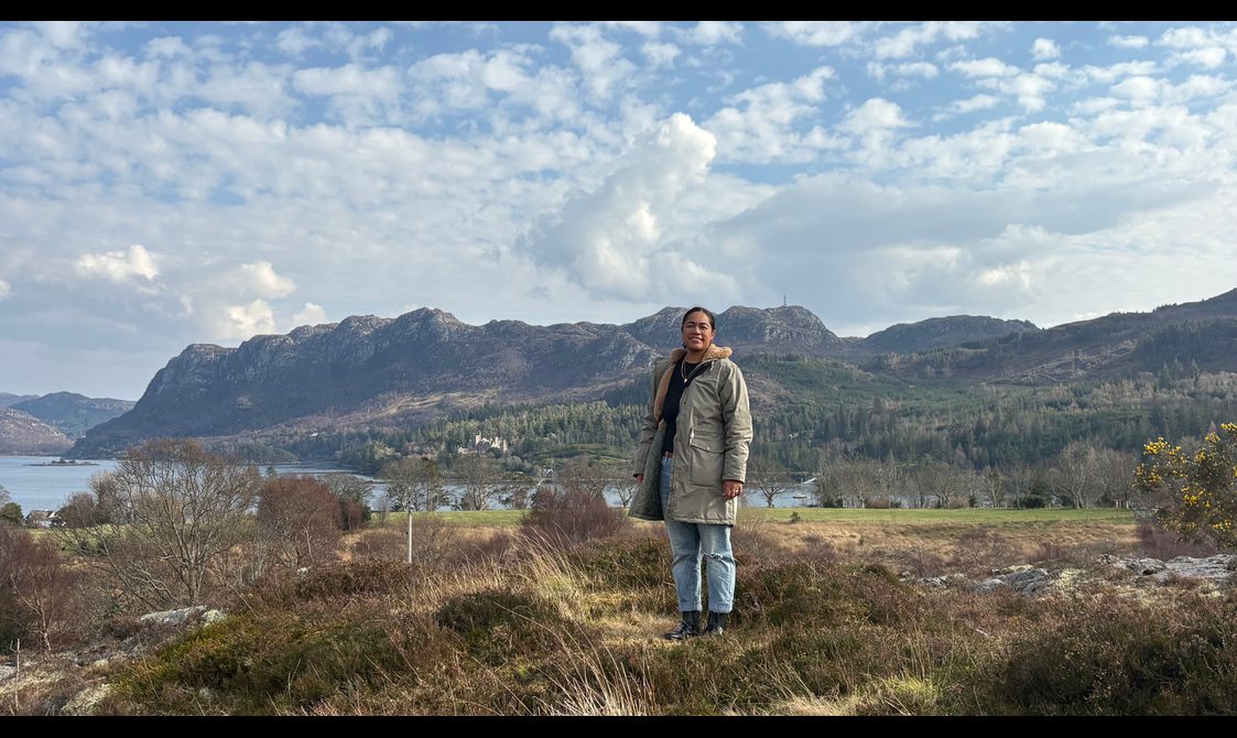 Person in front of Scottish landscape of hills and lake near Plockton.