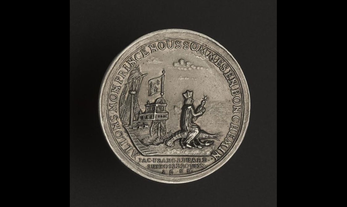 A round silver medal with inscription around the edges. A galley ship is depicted to the left side of the center, and a man seated on a lobster.