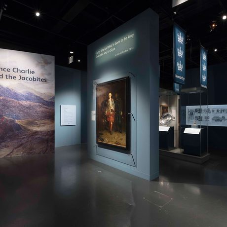 The entrance to the Bonnie Prince Charlie and the Jacobites, with a large painting on display and panels showing the Scottish highlands.
