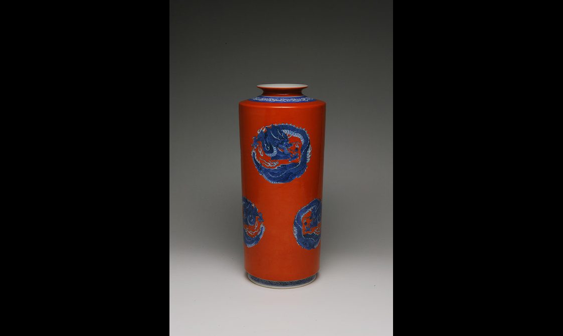 A red porcelain vase painted with blue dragons.