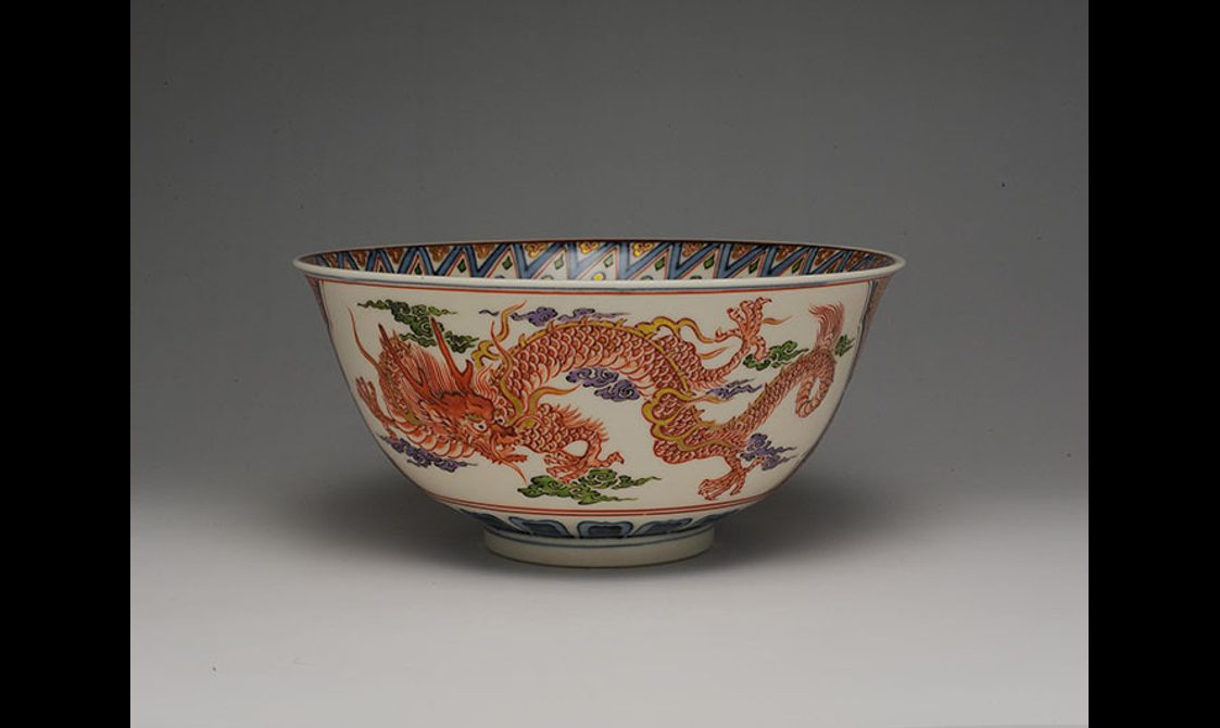 A porcelain bowl with a red dragon painted on it.