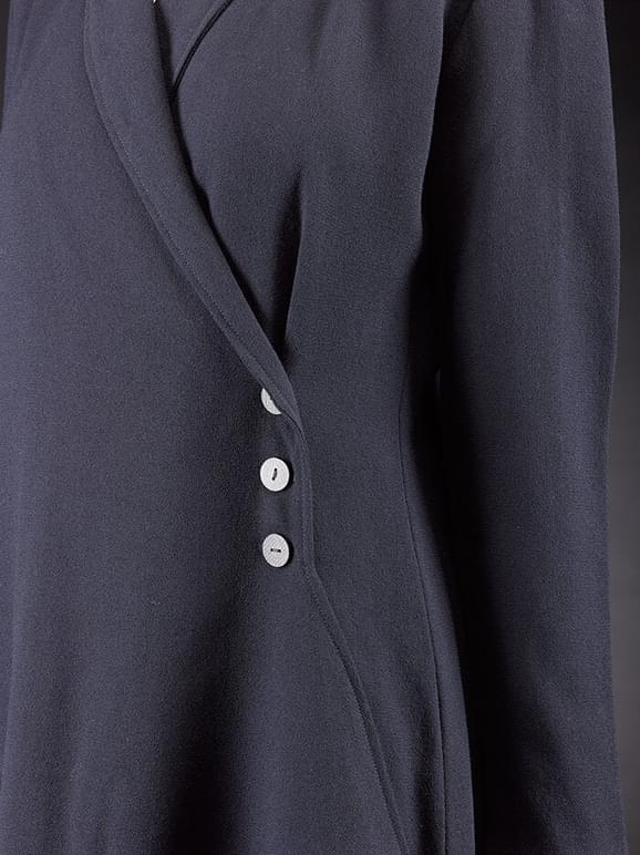 Detail of a navy wool crepe coat with three buttons fastening the coat.