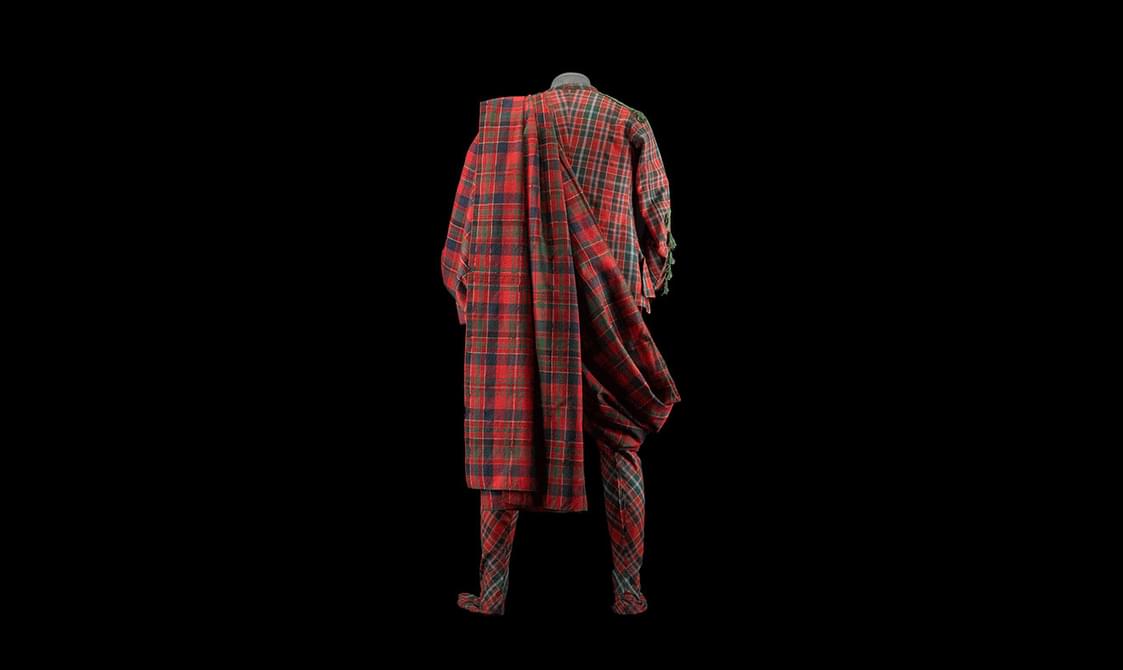 The back view of a red and green tartan full body suit with a fly plaid.