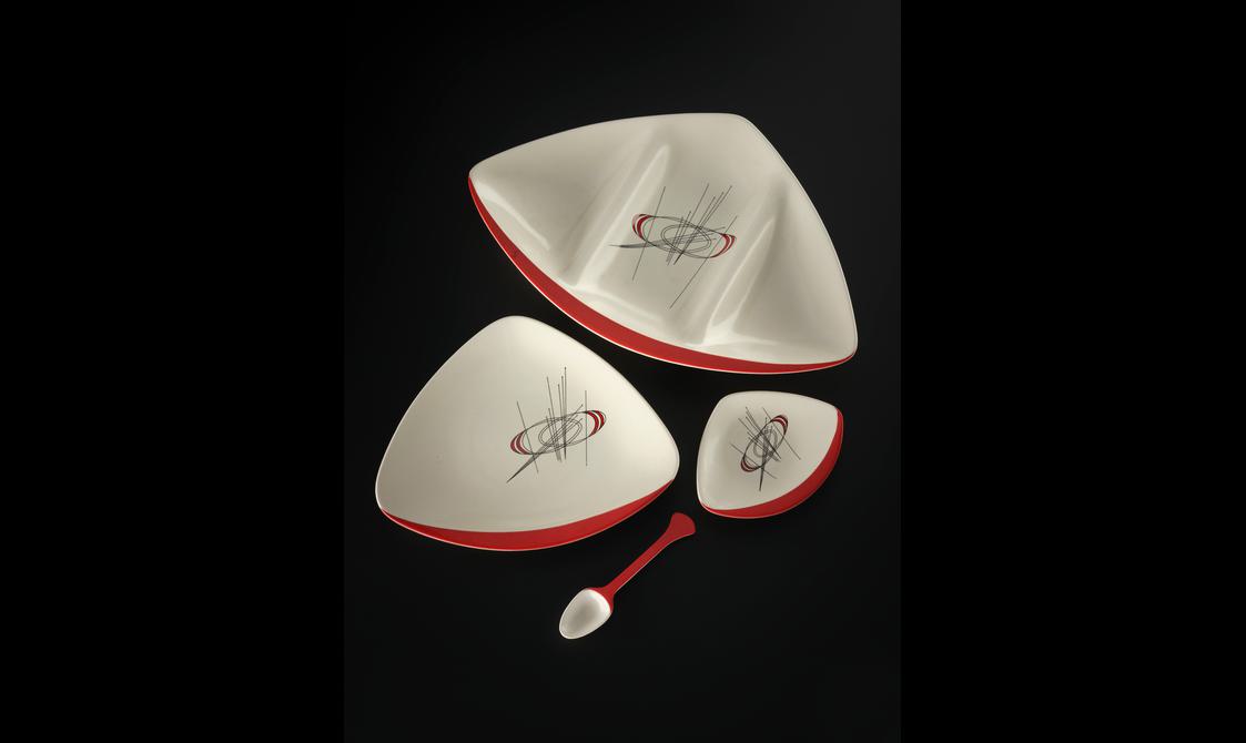 Orbit pattern triangular shaped earthenware segmented platter with rounded corners and one red flattened edge.