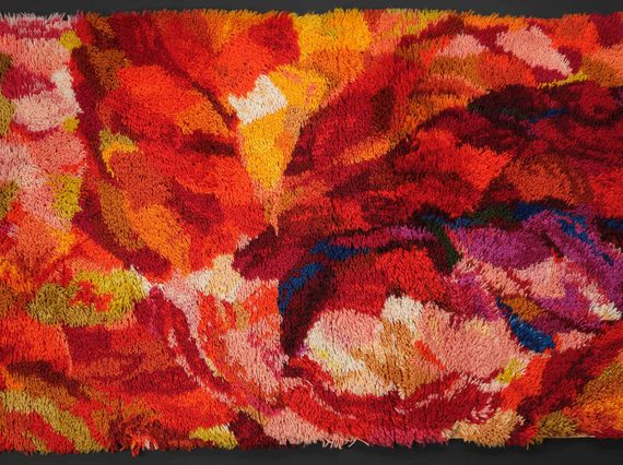 A colourful abstract textile design with colours of red, orange, yellow, and blue.