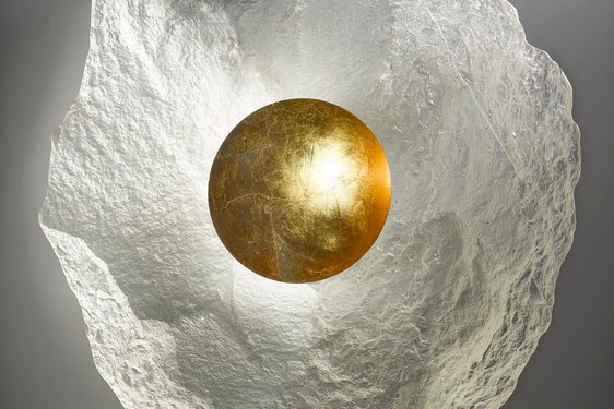 Irregularly shaped oval glass form. Mostly translucent, but with a round gold central well.