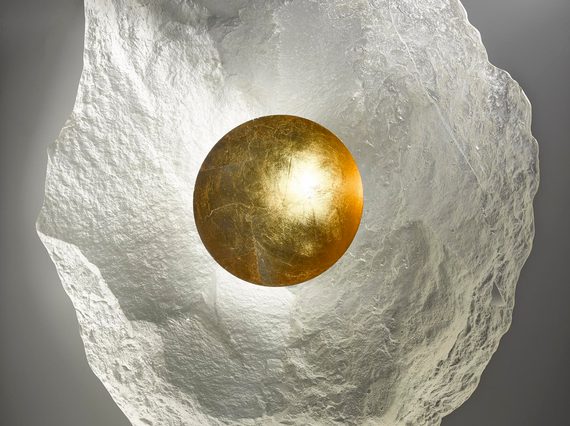 Irregularly shaped oval glass form. Mostly translucent, but with a round gold central well.