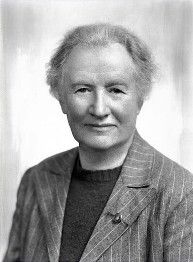 Portrait of a woman with short hair wearing a blazer and dark jumper