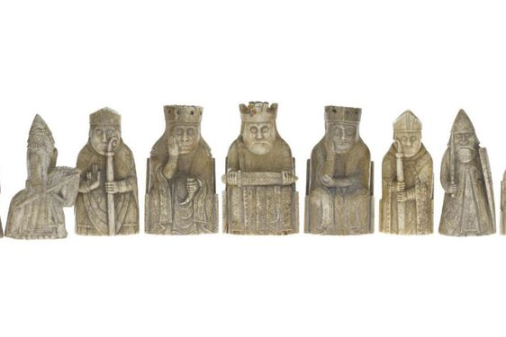 Gold Lewis chess pieces arranged in a row.