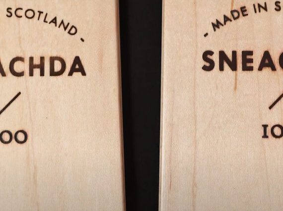 A close up of two wooden skis with made in scotland etched into the surface