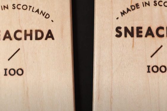 A close up of two wooden skis with made in scotland etched into the surface