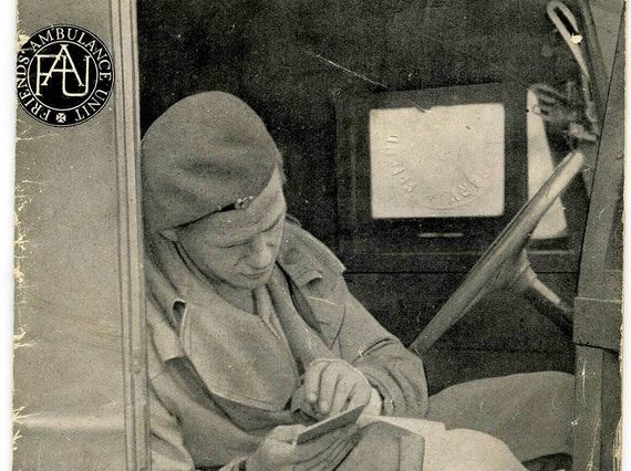 A poster advertising the Friends Ambulance Unit. A member of the unit is sitting in an ambulance with the door open, writing a note.