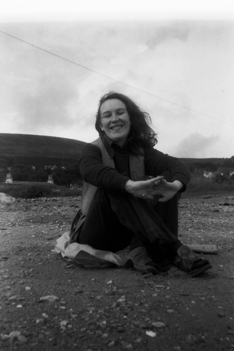 A black and white photo of Margaret Hubbard sitting on a beach.