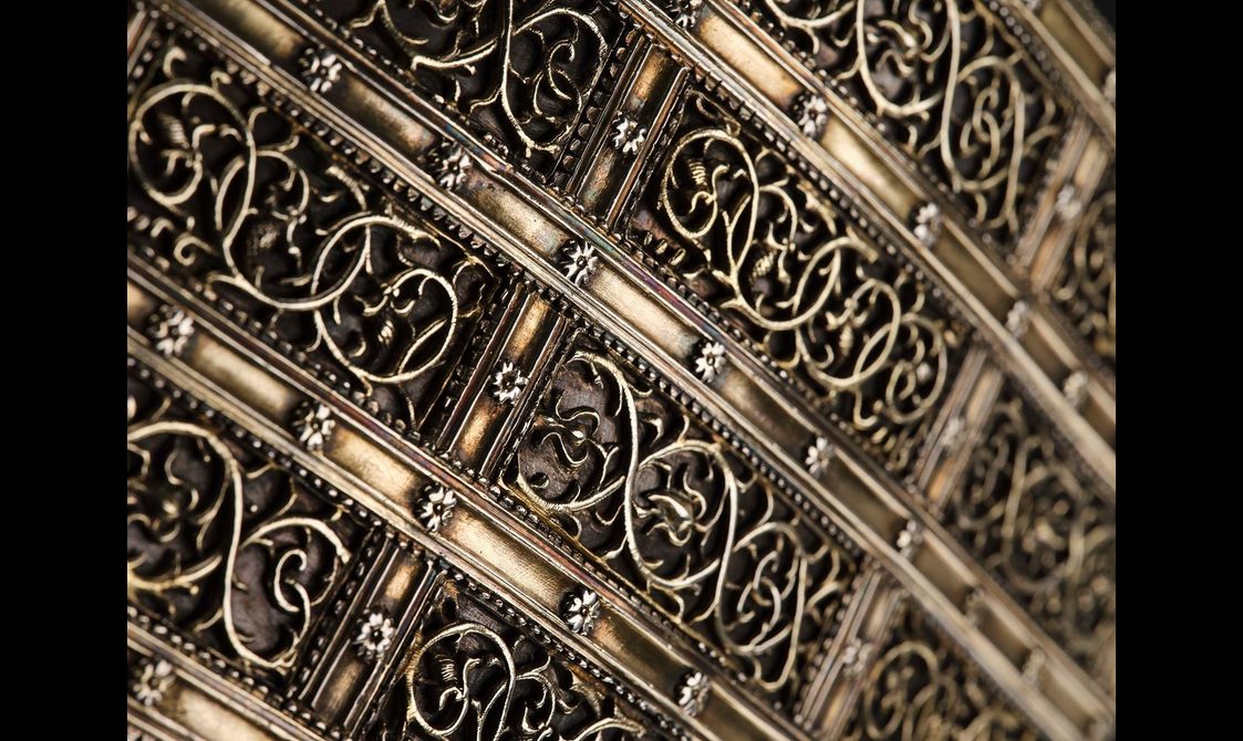 Close up of the lid decorated with ribbon-like lattice with flowers. Inside of rectangles are decorated with branch and leaf motifs.