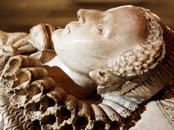 Detail of a marble tomb, showing a female head with ruffle collar.