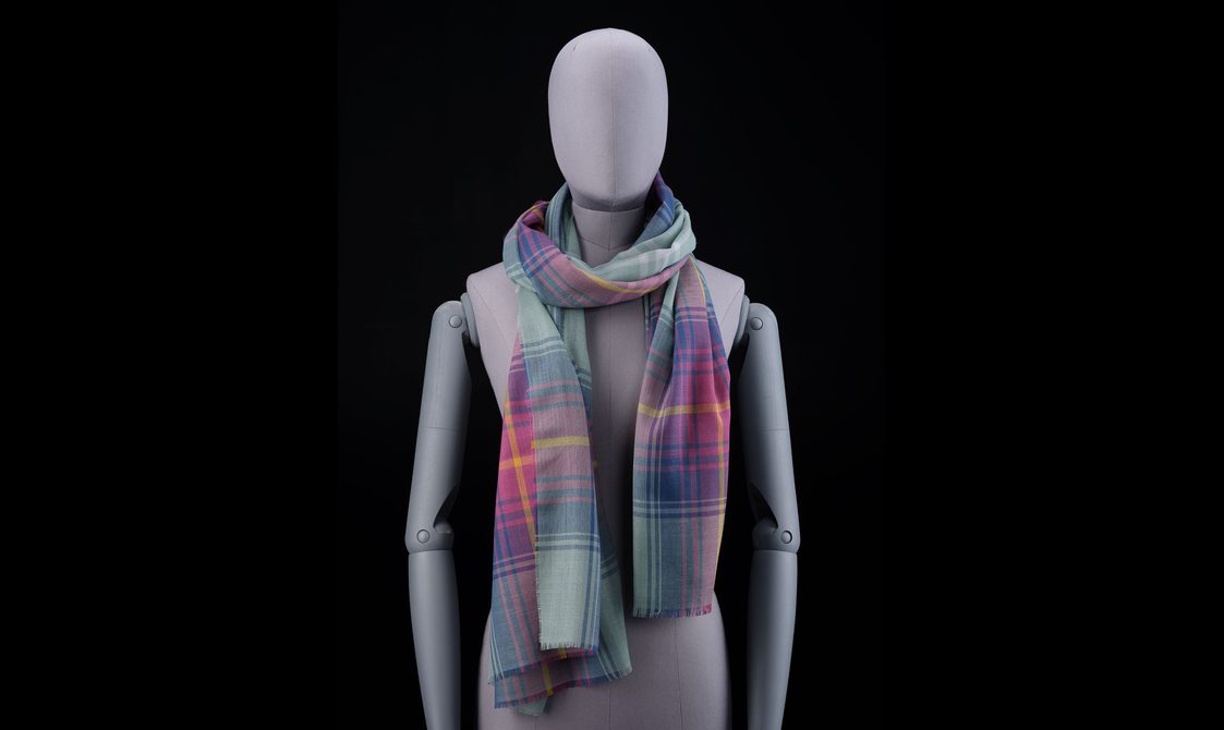 A mannequin wearing a purple, pink, and green scarf