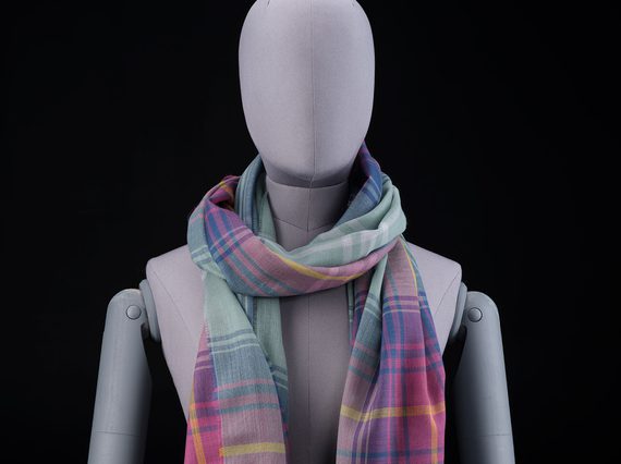 A mannequin wearing a purple, pink, and green scarf
