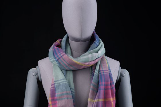 A mannequin wearing a purple, pink, and green scarf