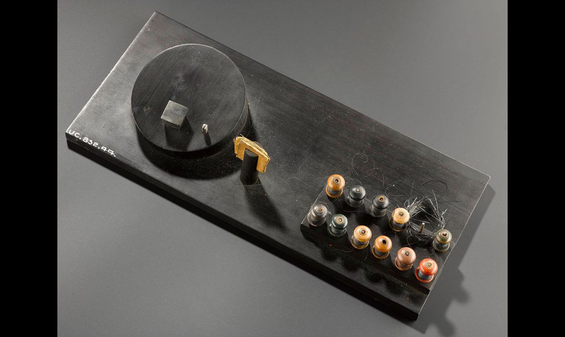 A metal rectangle with a disc on top with two rows of various knobs