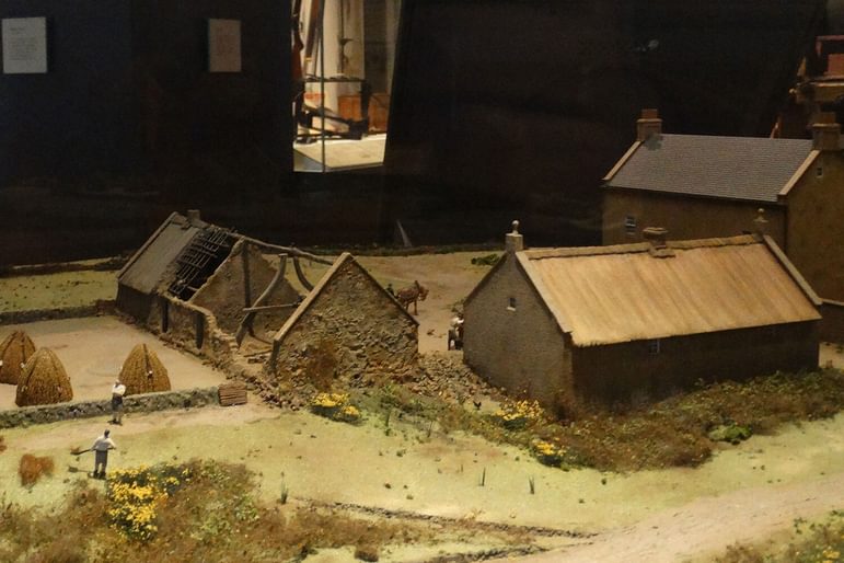 A model of a farm with farm houses being built.