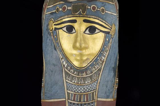 A mummy mask painted with hues of blue, red, and gold.