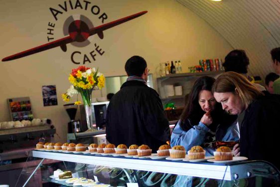 Visitors looking at an array of pastries in a café
