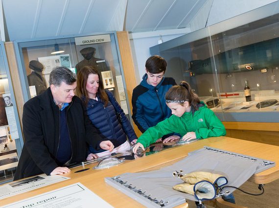 A family of four plays with an interactive game in the Fortunes of War gallery.