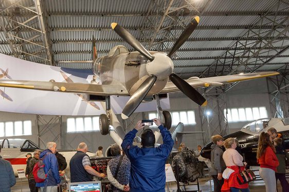 A visitor taking a photograph of the Spitfire aircraft in the Military Aviation hangar.