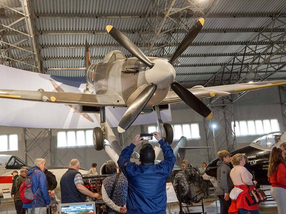 A visitor taking a photograph of the Spitfire aircraft in the Military Aviation hangar.