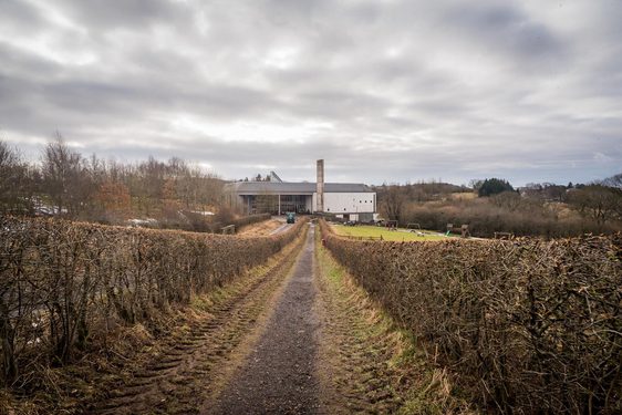 A footpath lined by hedges leading to the museum building of the National Museum of Rural life.