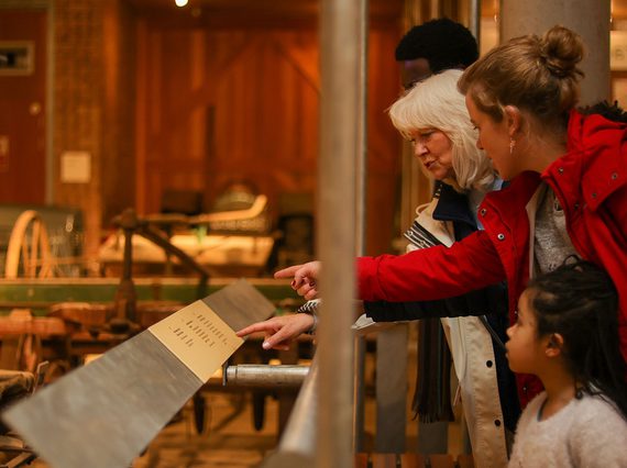 A family read a label in the tractor store at the National Musuem of Rural Life.
