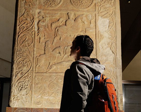 A visitor admires the Hilton of Cadboll stone, on display in Level -1 in the Early People gallery.