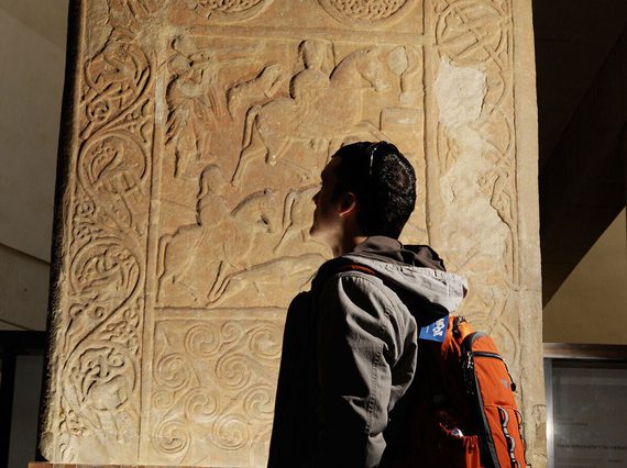A visitor admires the Hilton of Cadboll stone, on display in Level -1 in the Early People gallery.